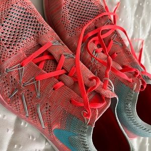 Size 9 Women’s Nike Free. Coral and aqua woven design.
